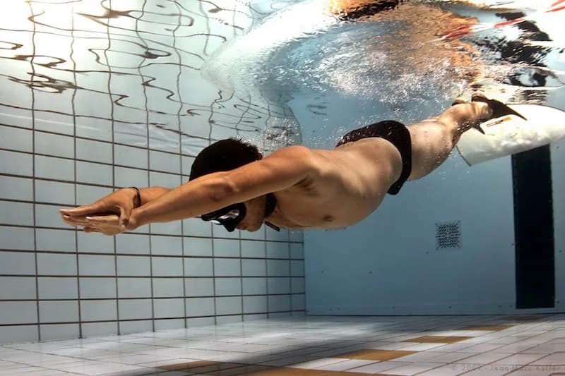 Freediver descending the line in clear blue water